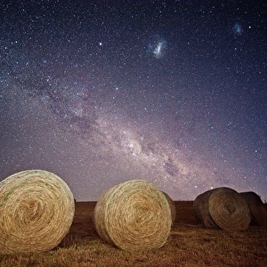 Milky way and magellanic clouds over hay bales