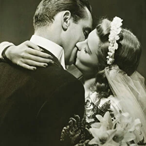 Bride and Groom kissing in studio, (B&W)