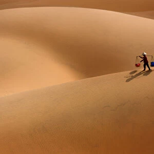Burden Woman in Sand dune