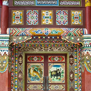 Colorful Tibetan designs on wall and door panels of temple, Jiuzhaigou National Scenic Area, Sichuan Province, China