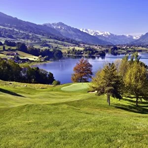 Golf course on the Lake of Gruyere or Lac de la Gruyere, Fribourg Alps at the back with Mt Moleson or Le Moleson, Canton of Fribourg, Switzerland