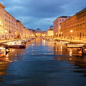 Grand canal with boats at night in Trieste, Italy