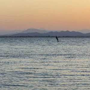 Kitesurfer, surfing on the blue lagoon of Ras Al Hadd Lagoon in the evening light, Ras Al Hadd, Ash Sharqiyah, Oman