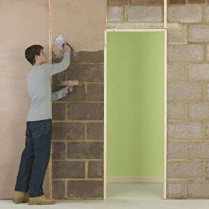Man applying plaster to wall