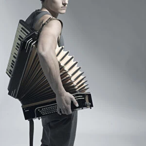 Man carrying an accordion, fashion shoot