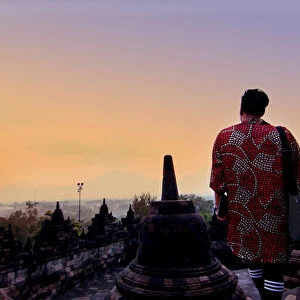 Man in dress overlooking mountains at Borobudur