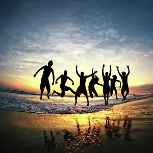 People jumping on beach at sunset in Costa Rica