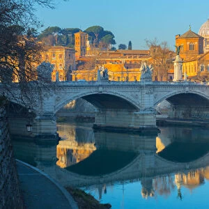Ponte Vittorio Emmanual II over the Tiber river in Rome, in the background the dome of St. Peter Basilica