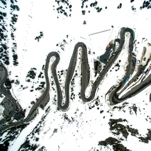 Stunning mountain road with nice curves between the snowy landscape and cars driving through it in the Andorra Pyrenees mountains with nice landscape