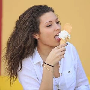 Teenager eating ice cream from a cone on the terrace of an ice cream parlour, Menton, Alpes-Maritimes, Provence-Alpes-Cote dAzur, France
