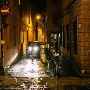 View on night city street in Old Town of Bologna during the heavy rain. Emilia-Romagna, Italy