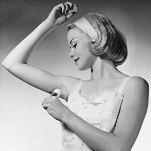 Woman putting on underarm deodorant