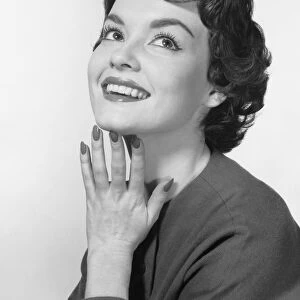 Woman smiling, posing with hand under chin