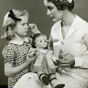Young girl and nurse holding doll