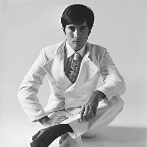 Young man sitting on white background, portrait
