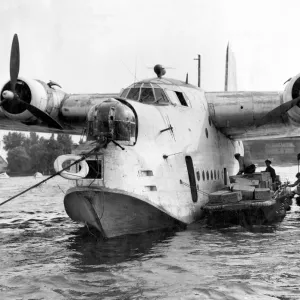 German workmen unload food from a British Royal Air Force flying boat, one of ten