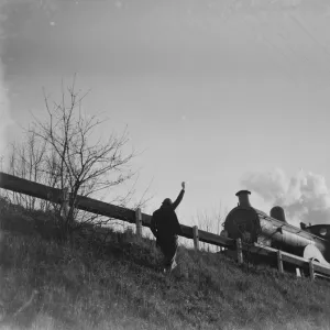 Muriel Haken waves to a passing train from a railway embankment. 1939