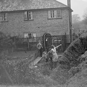 People watch from their back gardens as men work to clear the land slide on the Wellhall