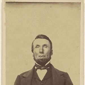 bearded man sans moustache seated hands crossed