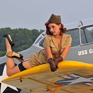 1940s style pin-up girl lying on a T-6 Texan training aircraft