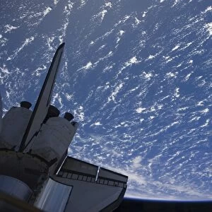 The aft section of space shuttle Discovery backdropped by planet Earth