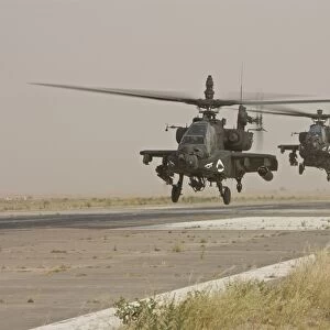 Two AH-64 Apache helicopters prepare to land on on the runway