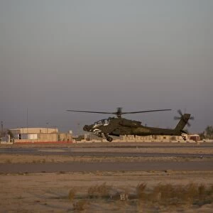 An AH-64D Apache Longbow Block III attack helicopter hovers above the runway