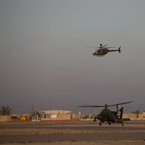 An AH-64D Apache Longbow Block III waits for an OH-58 Kiowa to clear his flight space