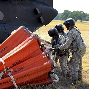 CH-47 Chinook helicopter crew prepare to install the Bambi Bucket on the aircraft