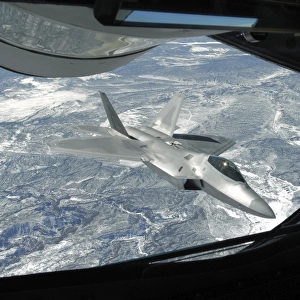 An F-22 Raptor banks away from a KC-135 Statotanker during a refueling operation