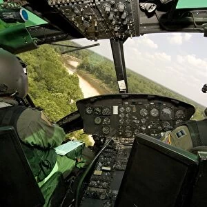 Two instructor pilots practice low flying operations in a UH-1H Huey helicopter