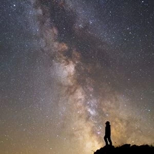A man on a mountain under the Milky Way on the Lago-Naki plateau in Russia