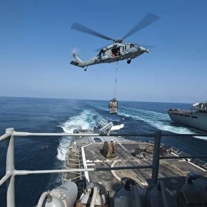 An MH-60S Sea Hawk brings pallets of supplies to USS Mobile Bay