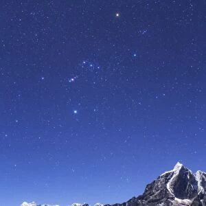 The Orion constellation above the moonlit landscape of the Himalayas in Nepal