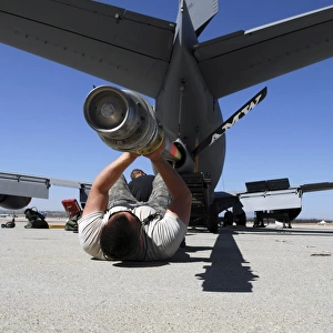 A U. S. Air Force Airman lifts the boom of a KC-135 Stratotanker