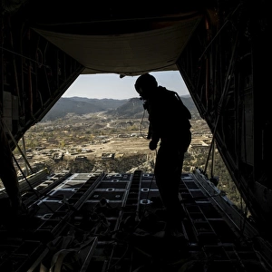 U. S. Air Force Airman pushes out pallets from a C-130H Hercules