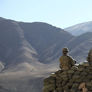 U. S. Army soldiers run communications equipment from a sandbag bunker in Afghanistan