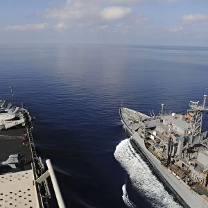 USNS Rainier transits next to USS Nimitz