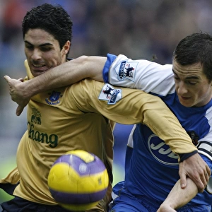 Wigan Athletics Baines challenges Evertons Arteta for the ball during their English Premier League