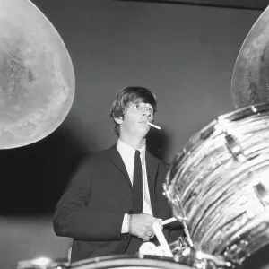 Ringo Starr smokes a cigarette at the drums as the Beatles perfo