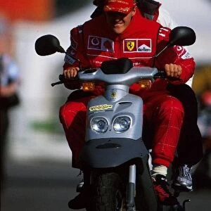 Formula One Testing: 2001 Formula One World Champion Michael Schumacher Ferrari takes his moped for a spin in the paddock