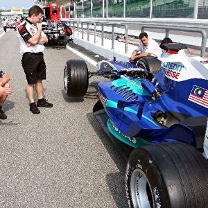 Formula One World Championship: BAR and Red Bull Racing mechanics look at a Sauber C24 in the pitlane