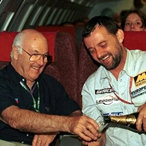 Formula One World Championship: European Aviation and Minardi team manager Paul Stoddart pours the champagne for TV Commentator Murray Walker