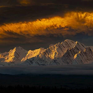 Dramatic golden clouds over the rugged Rocky Mountains in Alberta, Canada