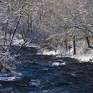 Water Flowing In A River With Snow Covered Shoreline; Fulford, Quebec, Canada