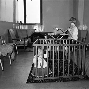9 month old Jane Turnock plays happily in her play pen as her mothers works away in