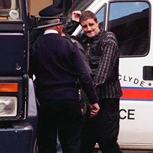 Actor Iain McColl is led away from court into a police van after he was remanded in