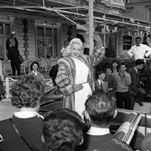 Actress Diana Dors waves to spectators and photographers on her arrival at the Cannes