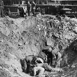 Aftermath of a V2 rocket attack on Kew, London. Workmen search the bottom of a