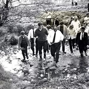 Beating the bounds - Llantrisant - Townspeople wade through a small brook led by Eddie